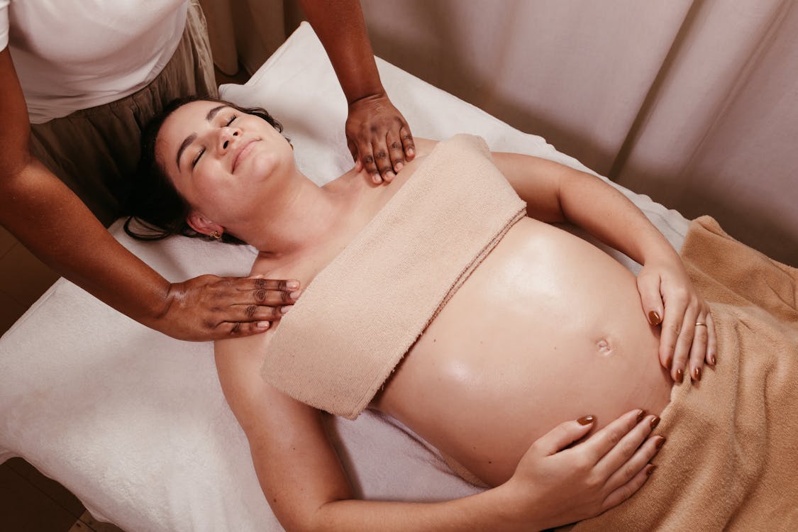 Pregnant woman receiving a gentle prenatal massage at a Chinese massage parlour in Tirana
