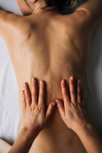 Therapeutic Back Massage – Pain Relief Therapist hands performing therapeutic back massage to relieve pain and tension