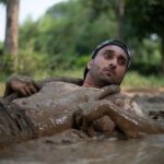 a man laying in the mud in a river