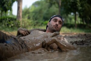 a man laying in the mud in a river